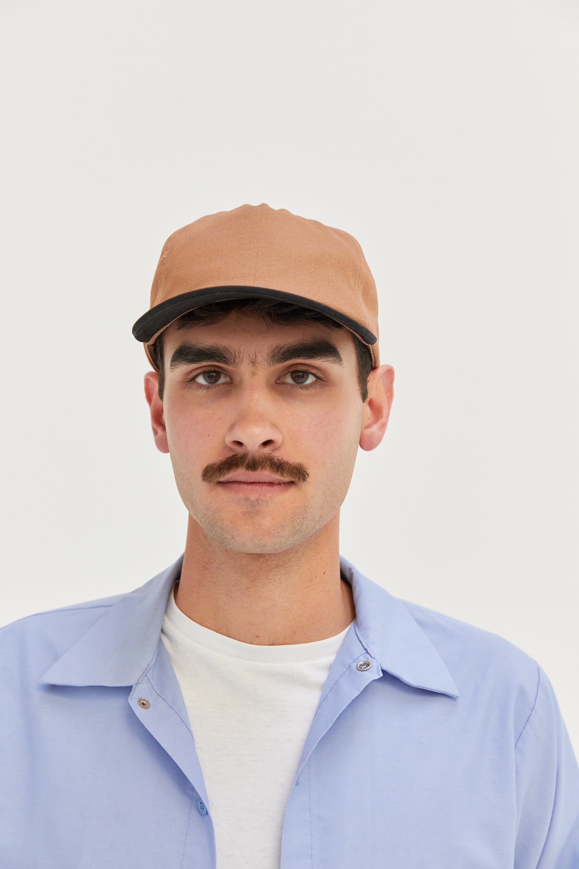 Male model wearing a WELD MFG Two-Tone Brushed Cotton Twill Workhorse Snapback Hat with a slightly structured 5-panel crown and contrasting curved brim, Dune Black
