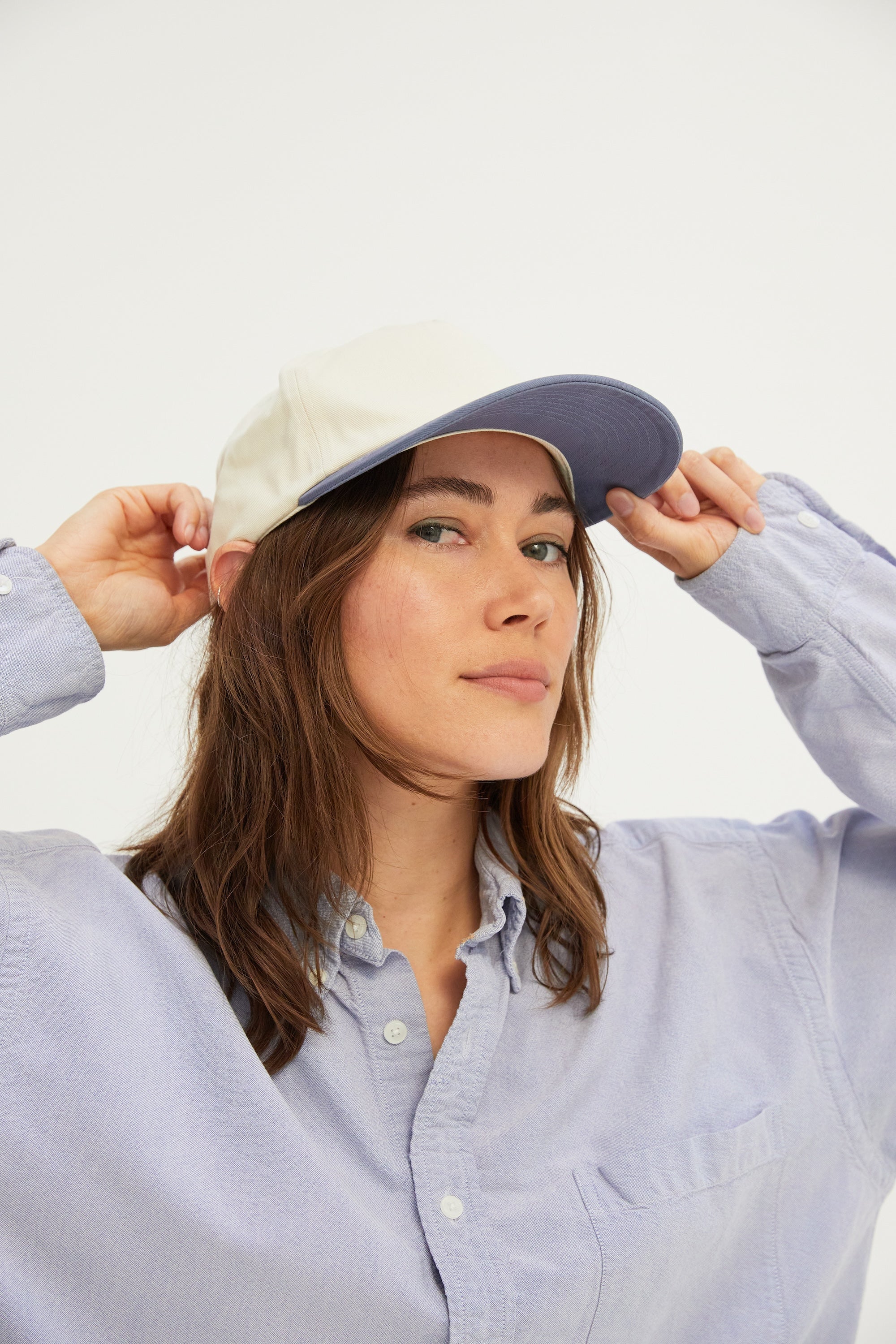 Female model wearing a WELD MFG Two-Tone Brushed Cotton Twill Workhorse Snapback Hat with a slightly structured 5-panel crown and contrasting curved brim.