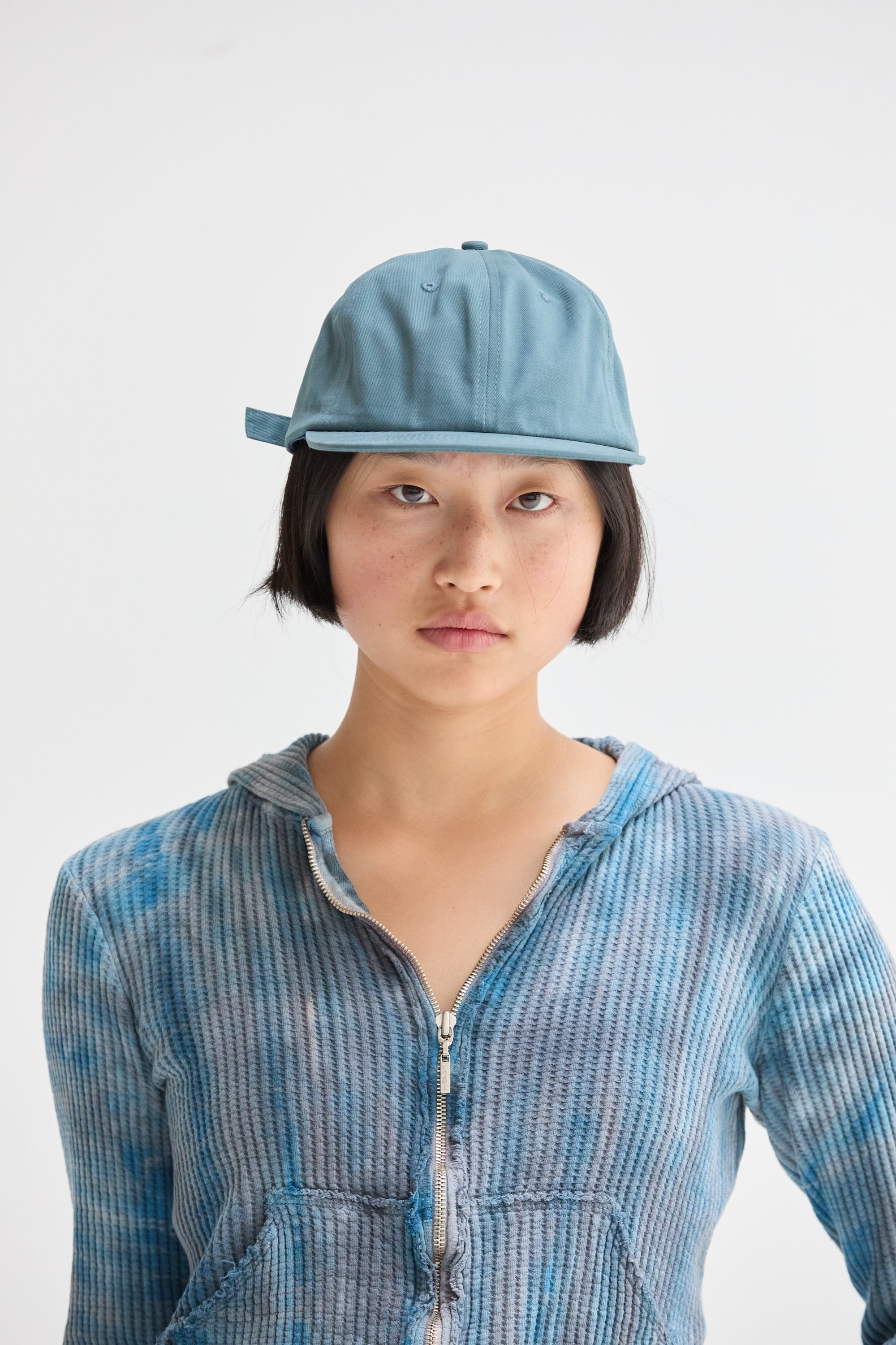 A female wearing a Slate Blue Weld Mfg Brushed Cotton 6 Panel Unstructured Field Trip Hat.